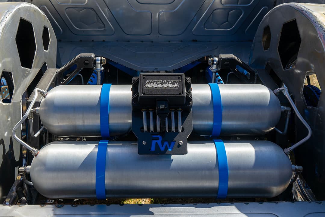 An Air Lift Performance air management kit on a vehicle at a car show.